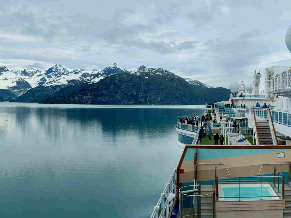 Alaska cruise ship sailing through the Inside Passage with snow-capped mountains in the background